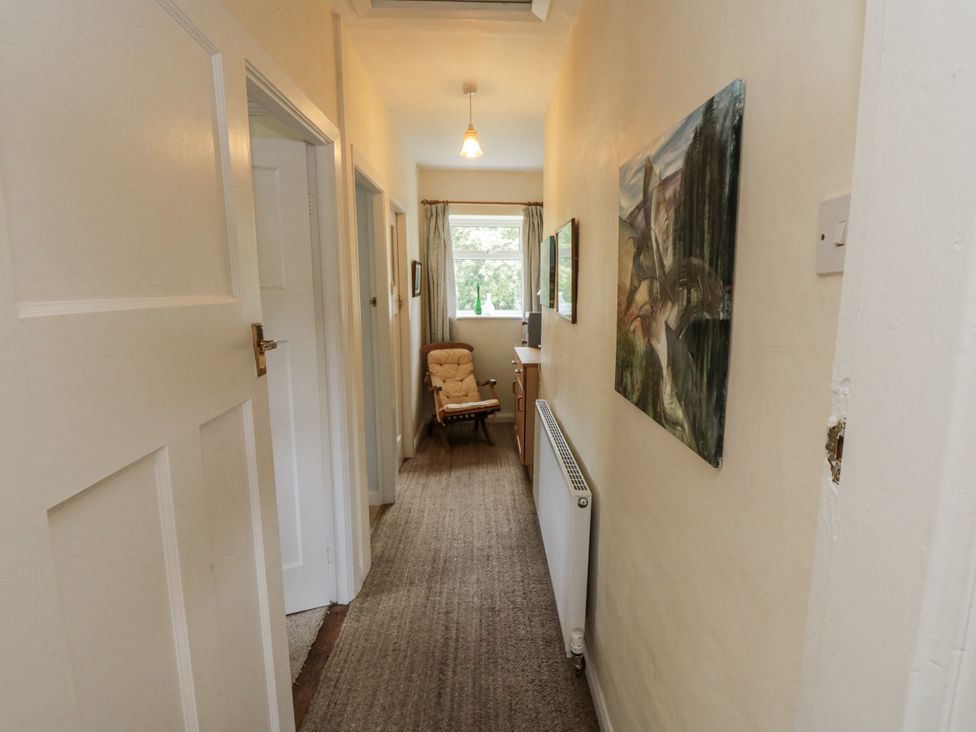 A hallway with an armchair and a radiator at Low Muffles Bridge