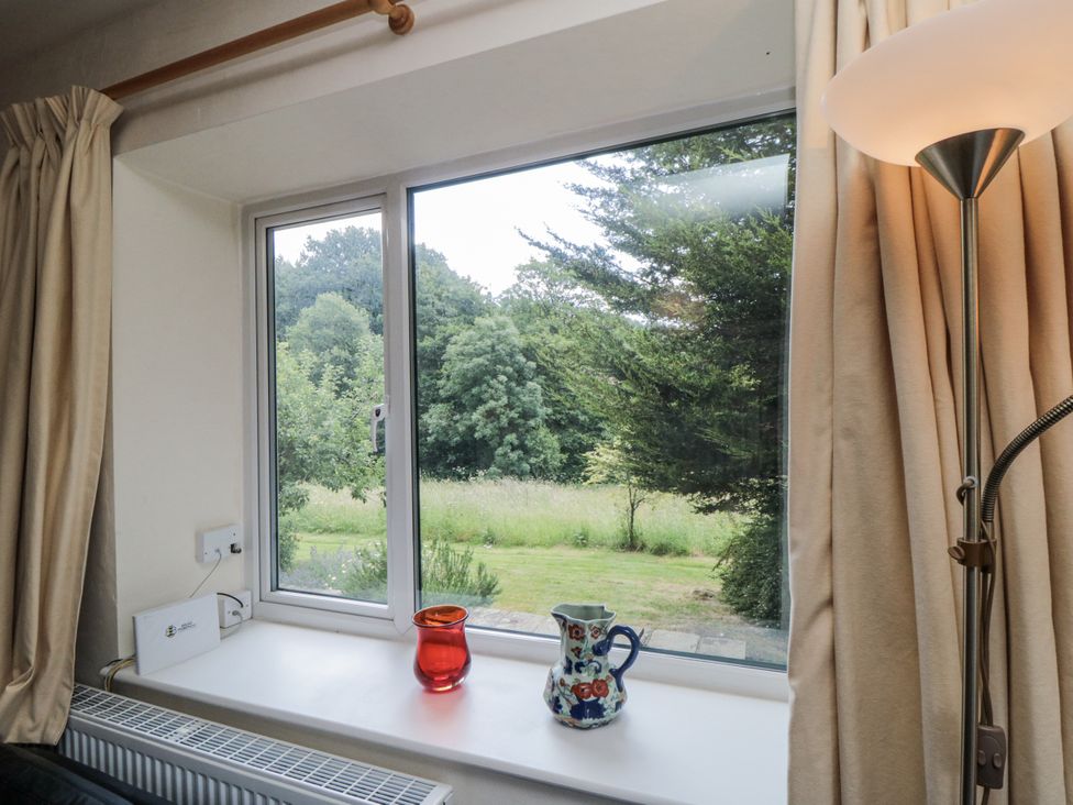 A window with curtains and a pitcher on the sill at Low Muffles Bridge 
