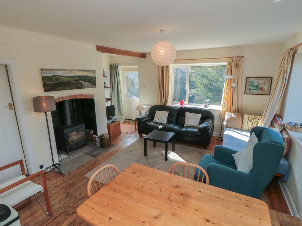 A living room with a fireplace and sofa at Low Muffles Bridge in Hartoft near Rosedale Abbey