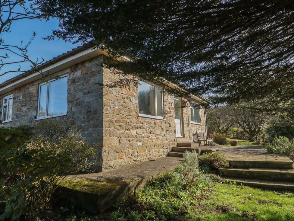 A stone building with windows and a door in the outdoor area at Low Muffles Bridge in Hartoft near Rosedale Abbey