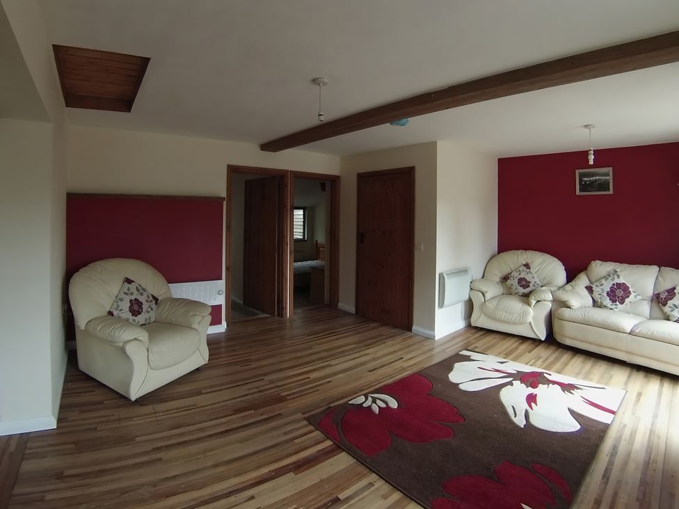 A living room with sofas and a rug at 1a Old Norwich Road Marsham near Aylsham