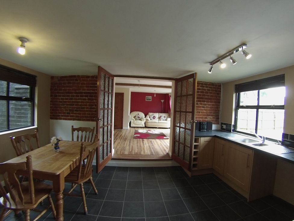 A kitchen with a table and chairs at 1a Old Norwich Road Marsham near Aylsham