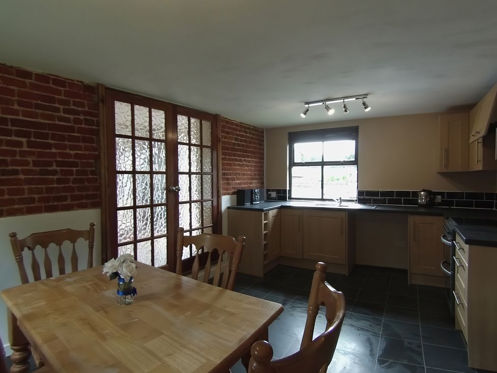 A kitchen with a table and chairs at 1a Old Norwich Road Marsham near Aylsham