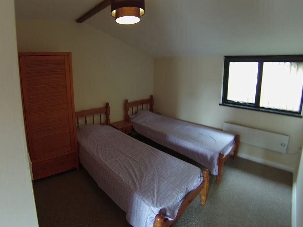 A bedroom with two single beds and a wardrobe at 1a Old Norwich Road Marsham near Aylsham