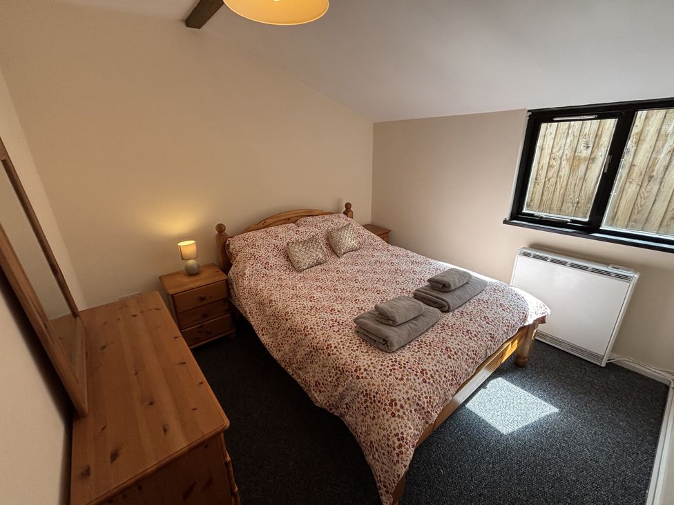 A bedroom with a bed and bedside table at The Studio in Marsham near Aylsham