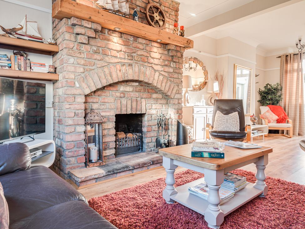 A living room with a brick fireplace and coffee table at Tranquility