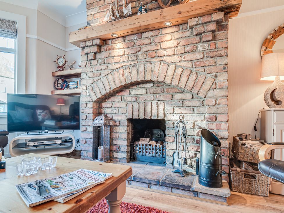 A living room with a fireplace and television at Tranquility