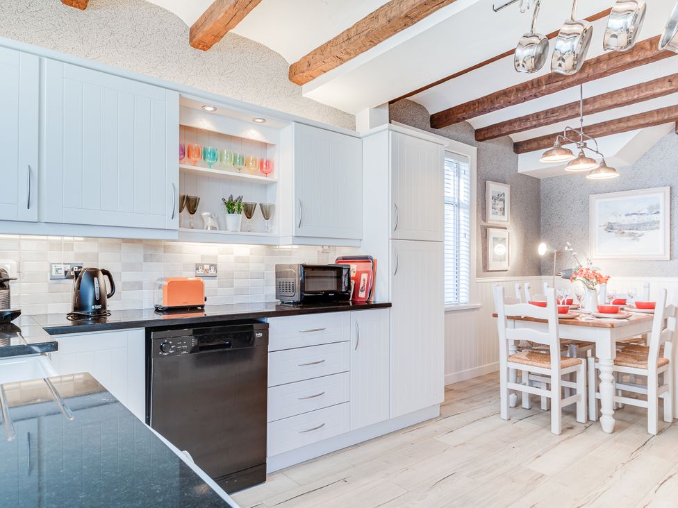 A kitchen with appliances and a dining table at Tranquility