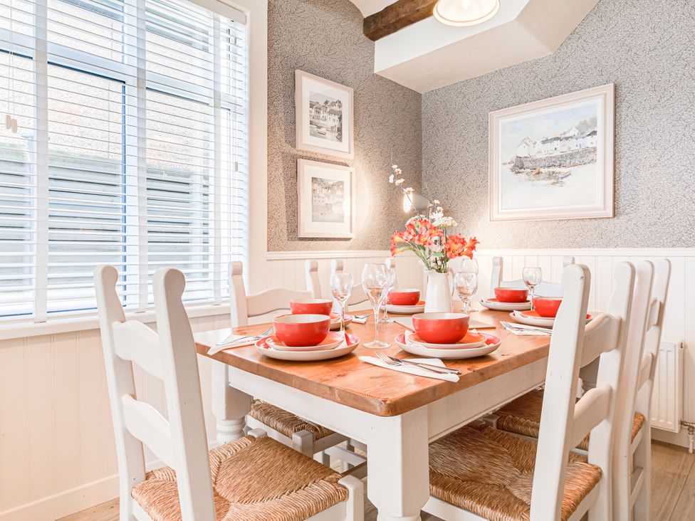 A dining room with a wooden table set for dinner at Tranquility