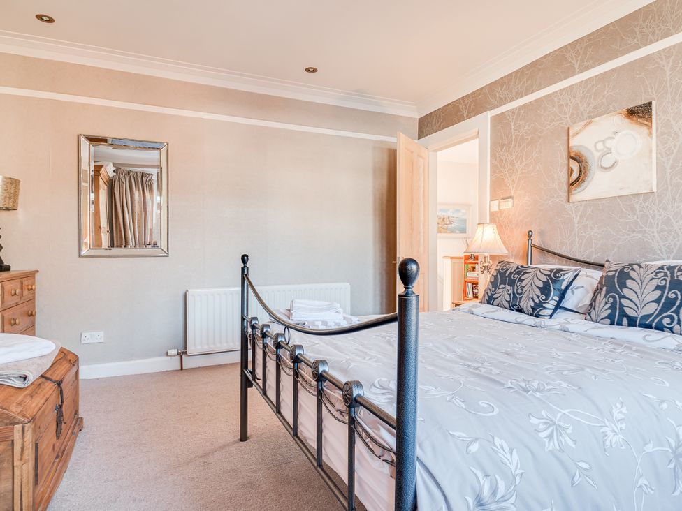 A bedroom with a metal bed and wooden chest at Tranquility in 