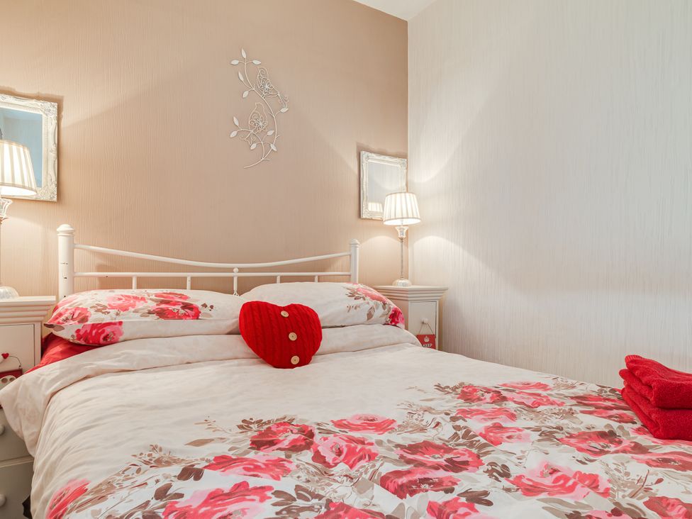 A bedroom with a bed and two lamps at Tranquility