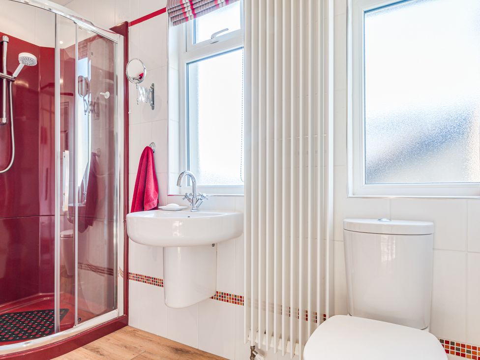 A bathroom with a shower, sink, toilet and a towel at Tranquility 