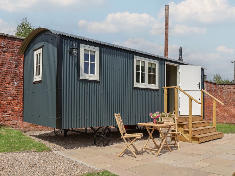 A shepherd's hut with a table and chairs at Shepherd's Hut in Wrexham