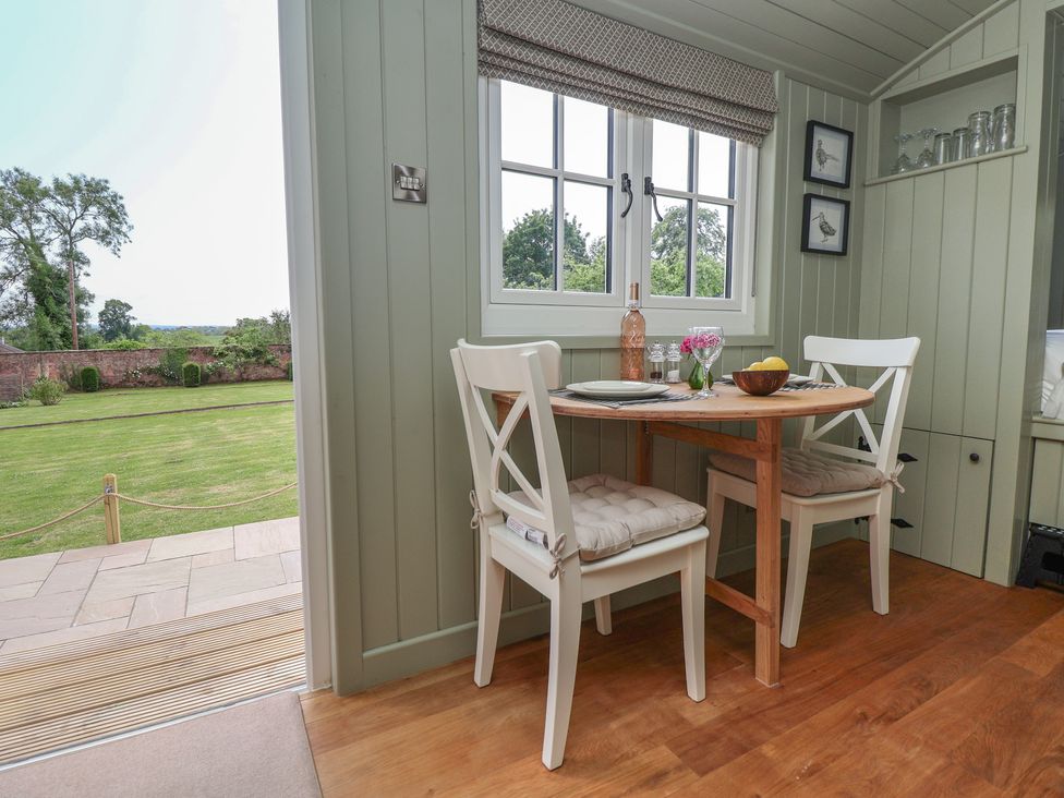A dining area with a table and chairs at Shepherd's Hut in Wrexham