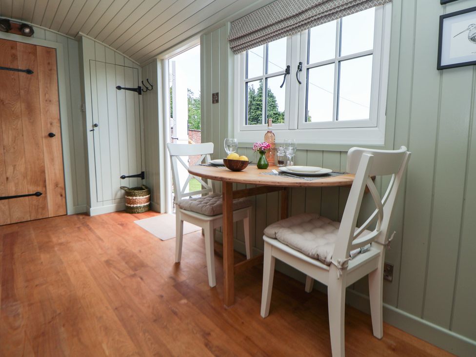 A dining room with a table and chairs at Shepherd's Hut in Wrexham