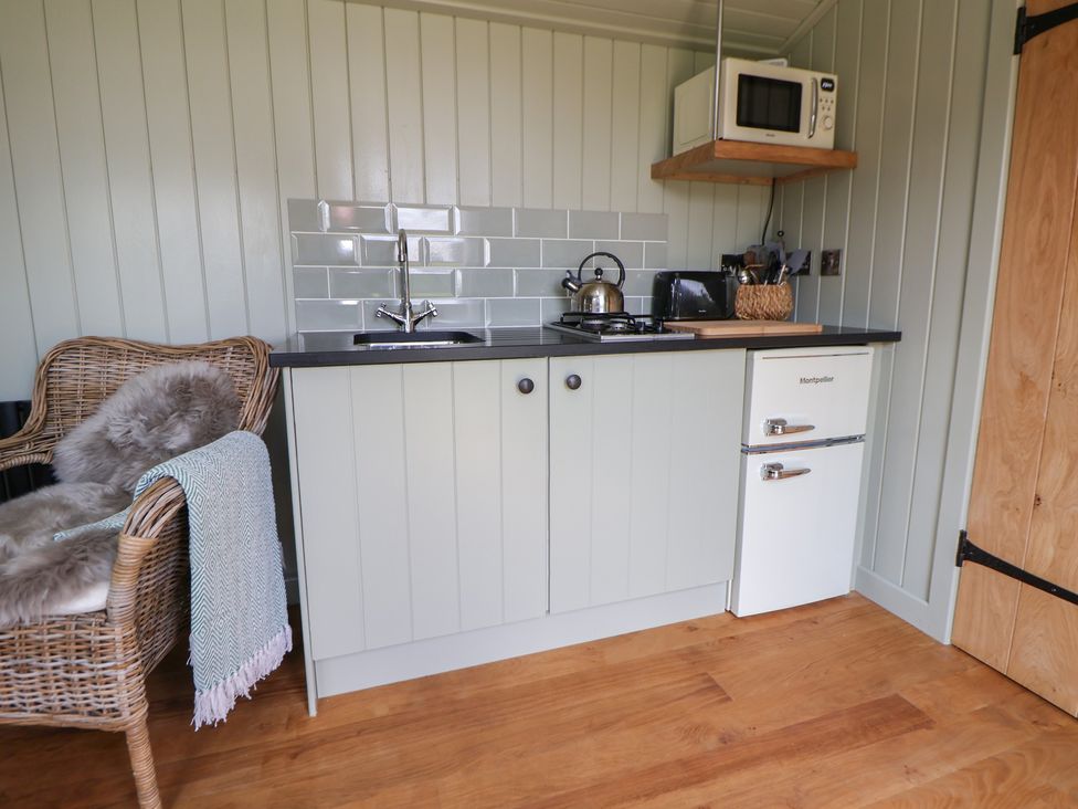 A kitchen with a sink and stove at Shepherd's Hut in Wrexham