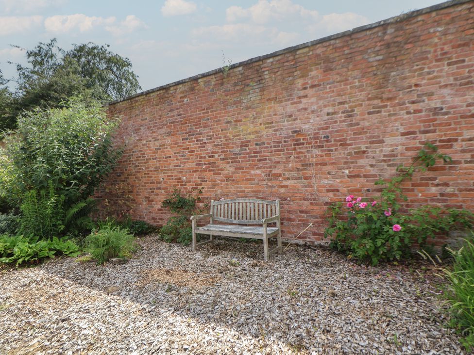 A garden with a bench and plants at Shepherd's Hut in Wrexham