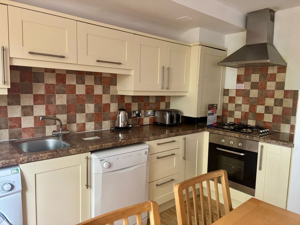 A kitchen with modern appliances and wooden furniture at Acorn Lodge Finlakes Holiday Park near Chudleigh