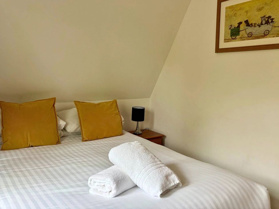 A bedroom with a bed and cushions at Acorn Lodge in Finlakes Holiday Park near Chudleigh
