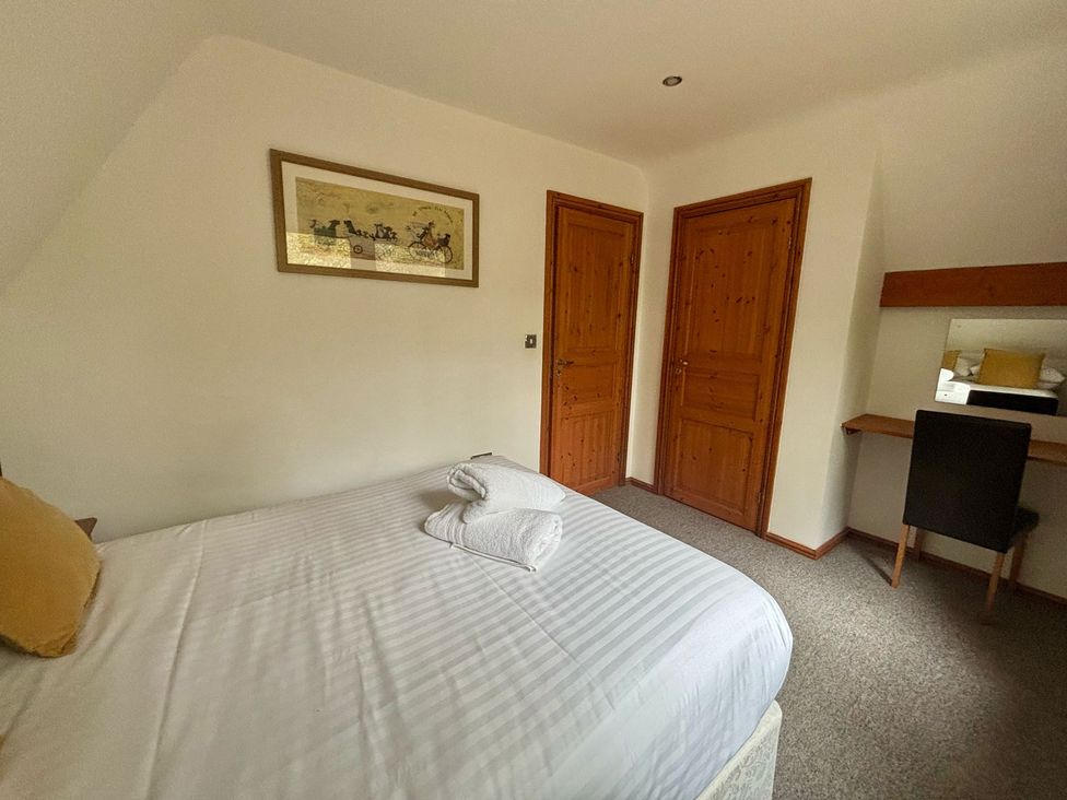 A bedroom with a double bed and desk at Acorn Lodge Finlakes Holiday Park near Chudleigh