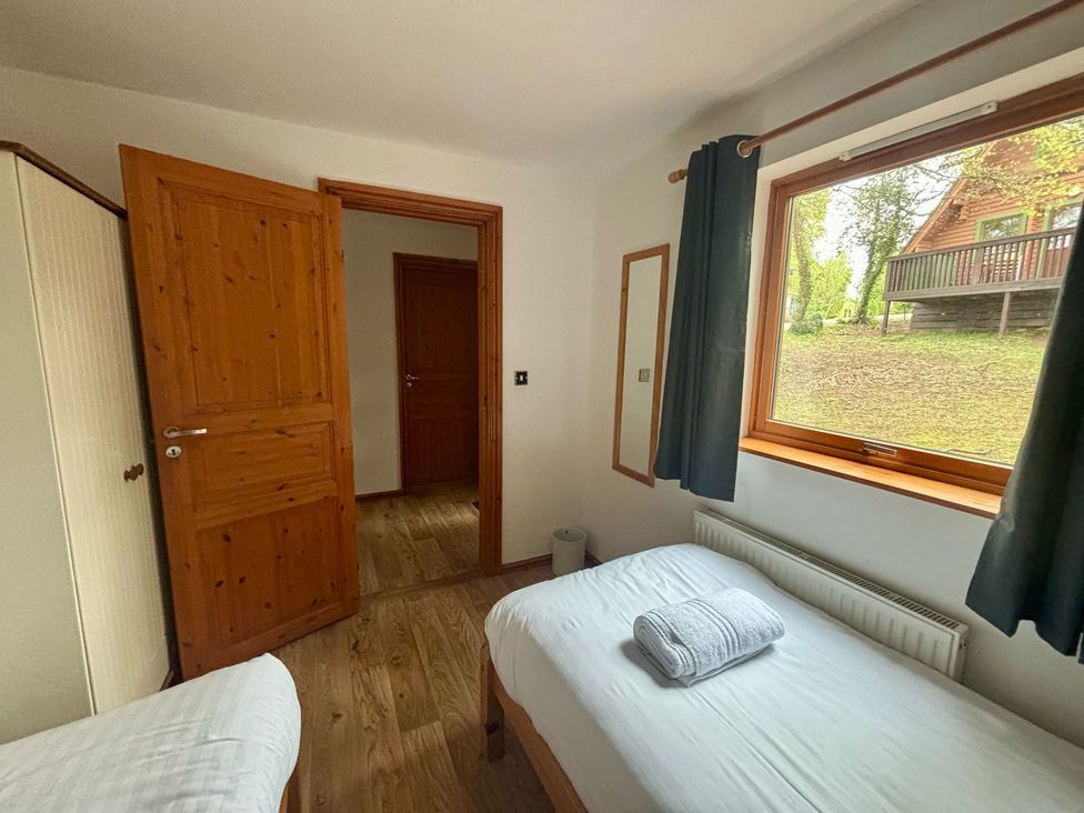 A bedroom with two beds and a window at Acorn Lodge near Finlakes Holiday Park Chudleigh