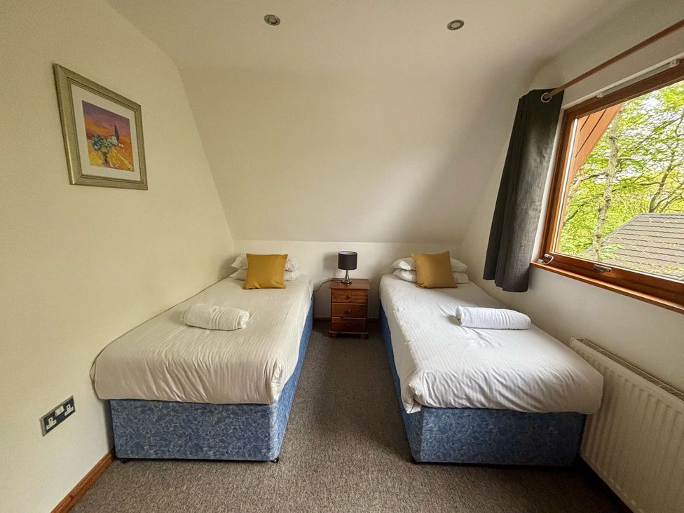 A bedroom with two single beds and a window at Acorn Lodge Finlakes Holiday Park near Chudleigh