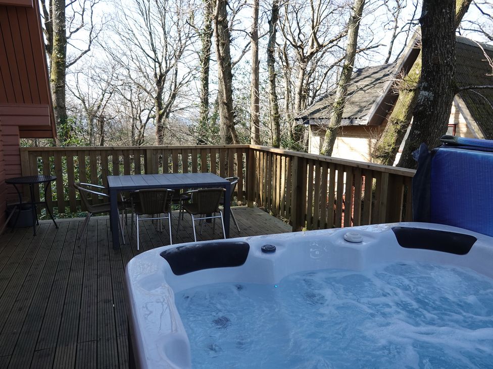 An outdoor space with a hot tub and dining furniture at Acorn Lodge Finlakes Holiday Park near Chudleigh