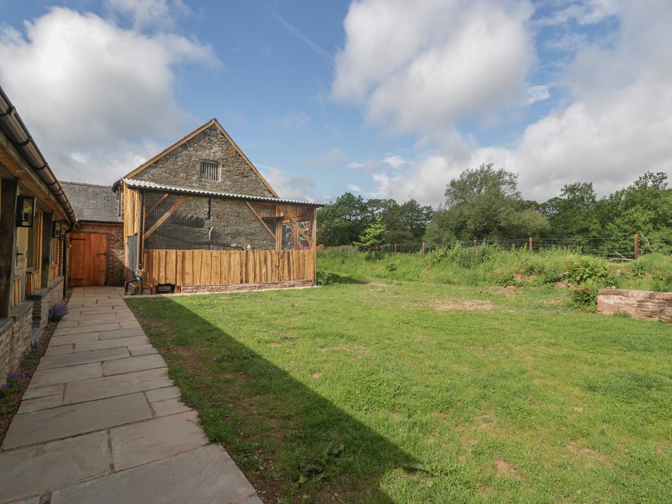 An outdoor area with a stone building and a path at Monnow in Pandy near Longtown (hereford)