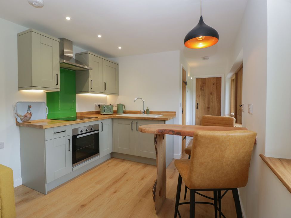 A kitchen with cabinets and appliances at Monnow in Pandy near Longtown (hereford)