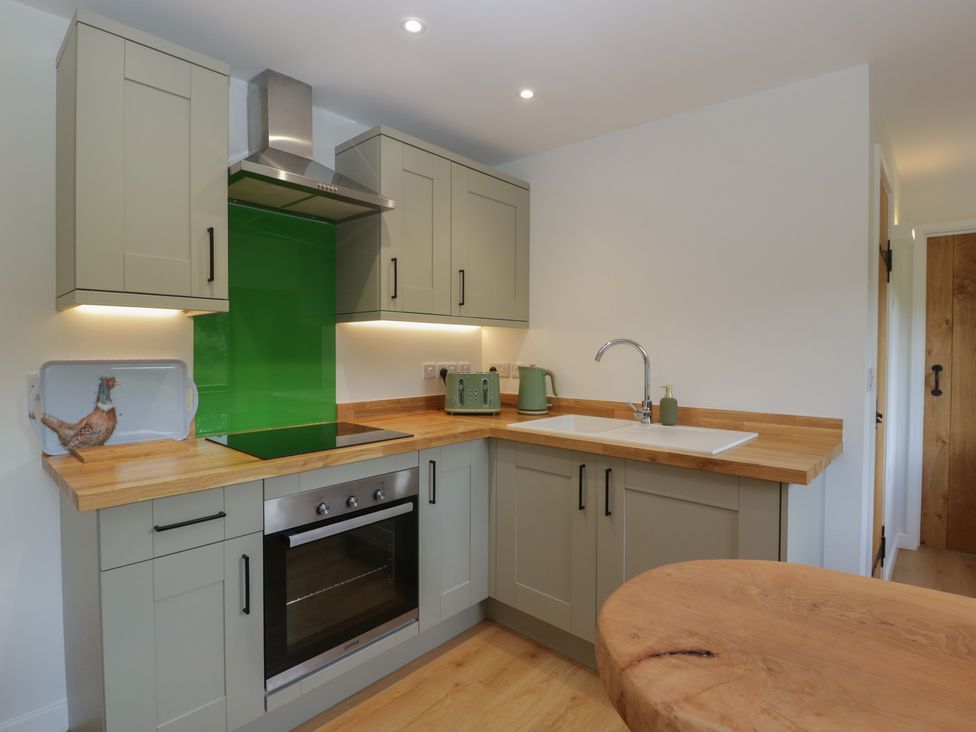 A kitchen with cabinets, sink, oven, and countertop at Monnow, Pandy near Longtown (hereford)