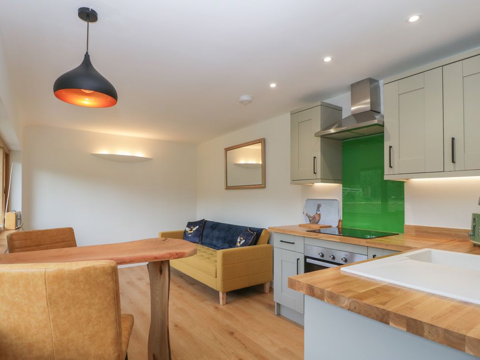 A kitchen with a dining table and chairs at Monnow in Pandy near Longtown (hereford)