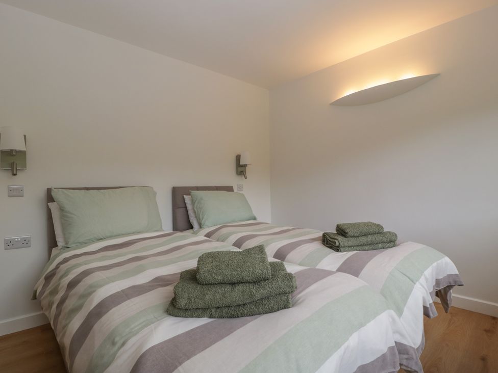 A bedroom with twin beds and towels at Monnow in Pandy near Longtown (hereford)