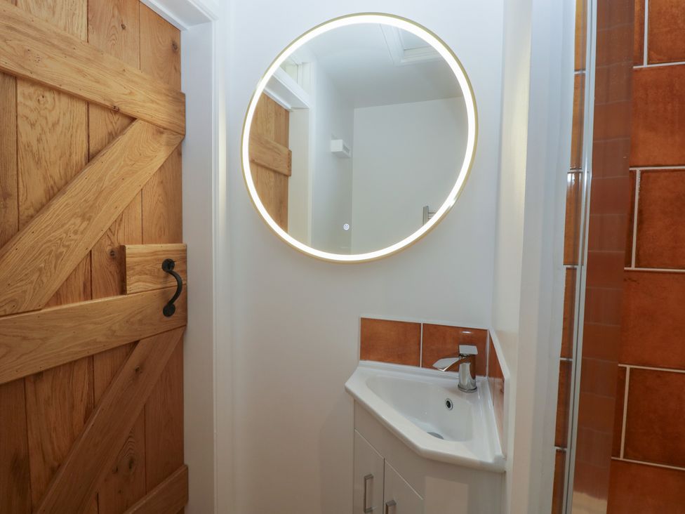 A bathroom with a mirror and sink at Monnow Pandy near Longtown (hereford)