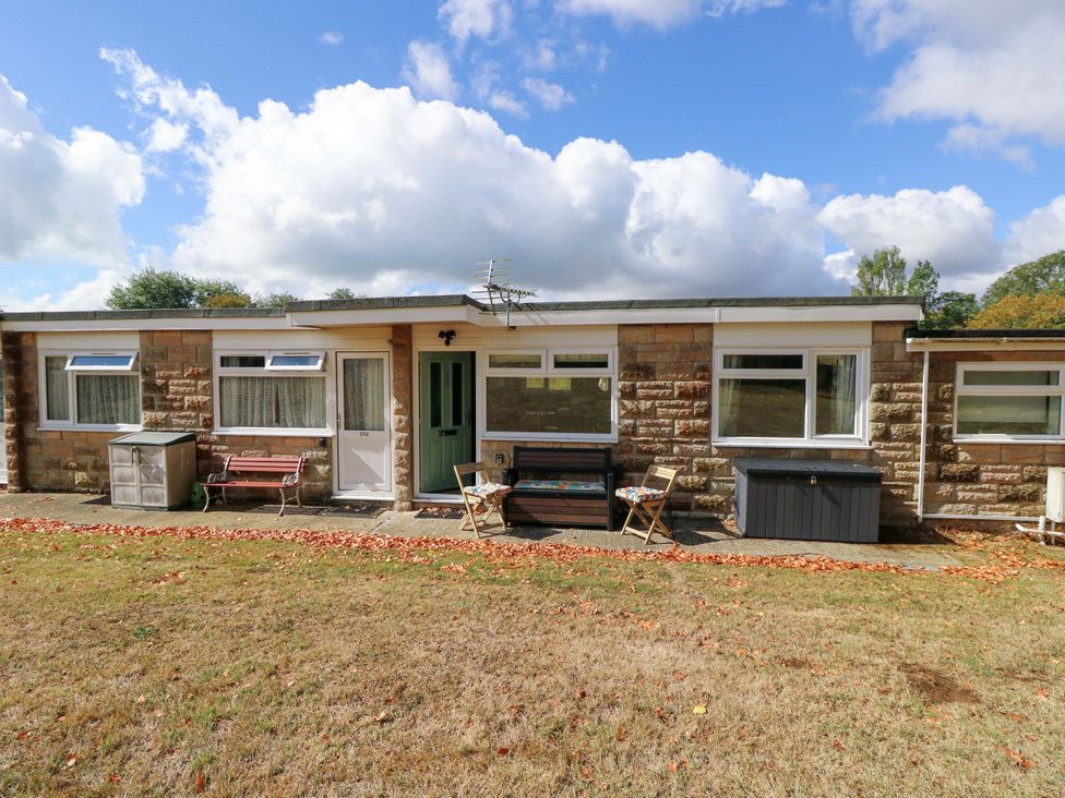 An outdoor view of a chalet with a front door and seating at No 157 Sandown Bay Holiday Chalet 'Field View' Sandown