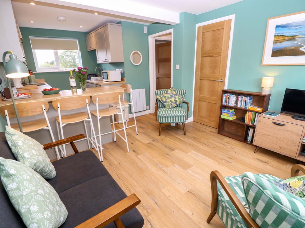A living room with a sofa and dining area at No 157 Sandown Bay Holiday Chalet 'Field View' Sandown