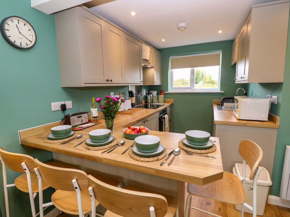 A kitchen with a dining table set for four at No 157 Sandown Bay Holiday Chalet 'Field View' Sandown
