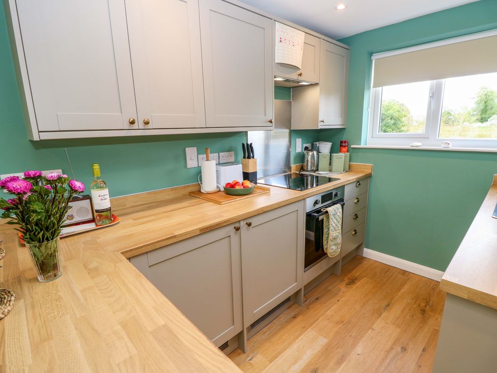 A kitchen with cabinets and appliances at No 157 Sandown Bay Holiday Chalet 'Field View' Sandown