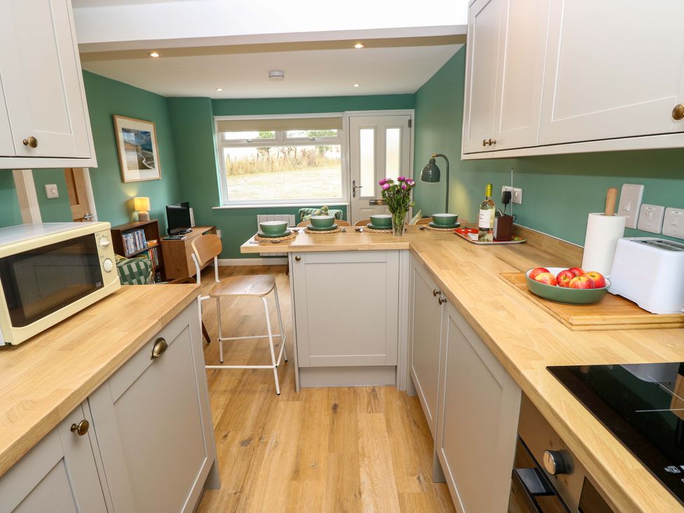 A kitchen with a table and chairs at No 157 Sandown Bay Holiday Chalet 'Field View' in Sandown