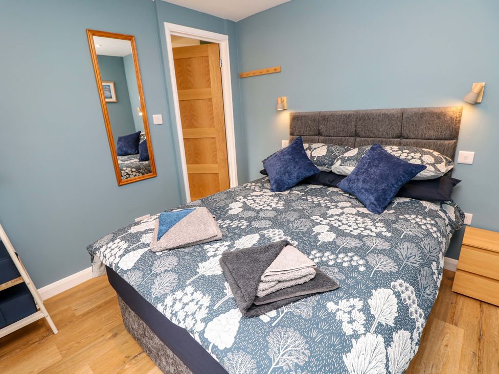 A bedroom with a bed and mirror at No 157 Sandown Bay Holiday Chalet 'Field View' in Sandown