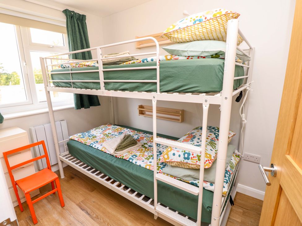 A bedroom with bunk bed and orange chair at No 157 Sandown Bay Holiday Chalet 'Field View' Sandown