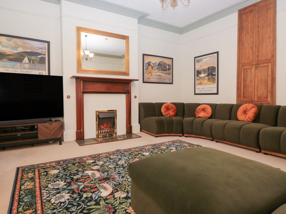 A living room with a television and a fireplace at Norwood House in Ambleside