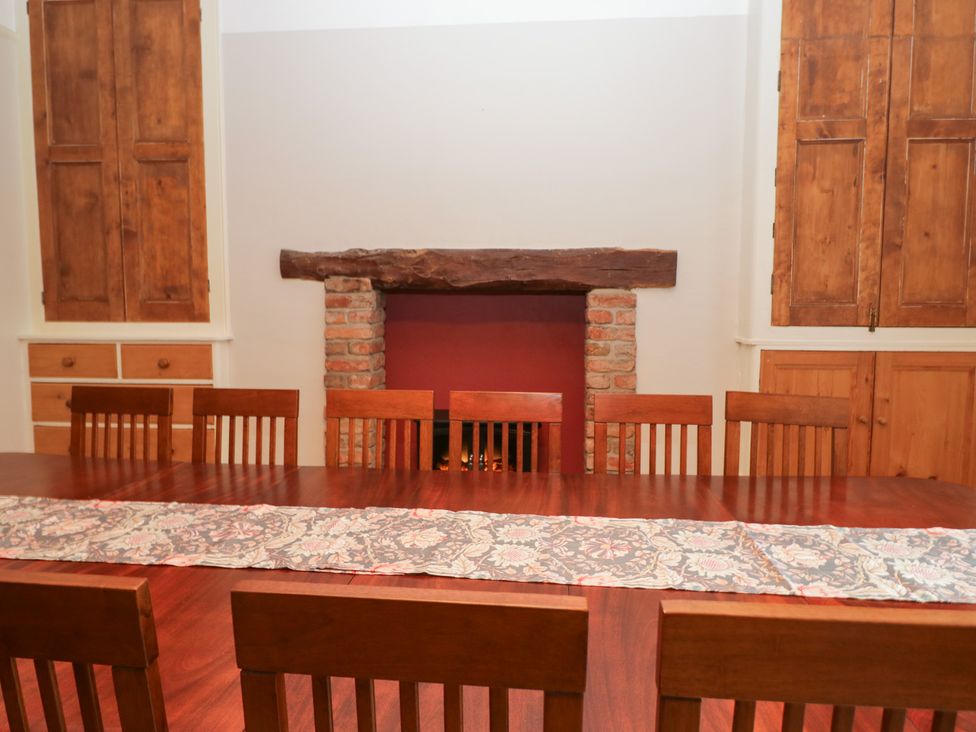 A dining room with a long table and chairs at Norwood House in Ambleside