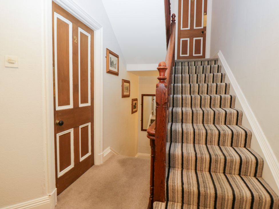 A hallway with stairs and a door at Norwood House in Ambleside