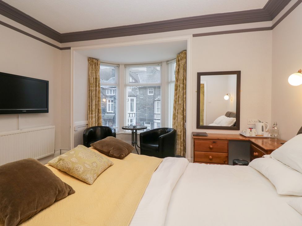 A bedroom with a bed and a television at Norwood House in Ambleside