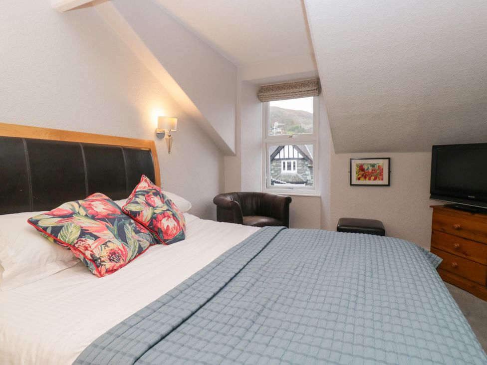 A bedroom with a bed and an armchair at Norwood House Ambleside