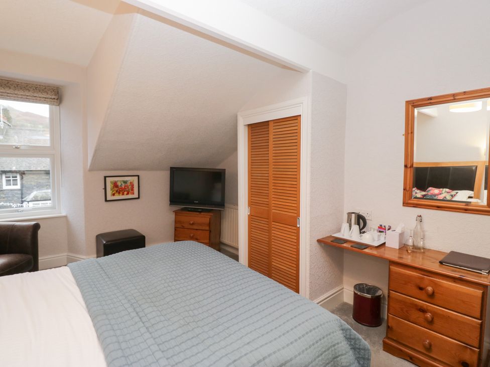 A bedroom with a bed, television, and dresser at Norwood House in Ambleside