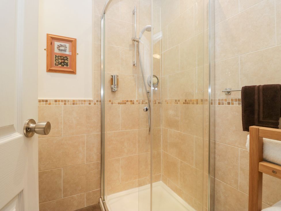A bathroom with a shower and a towel rack at Norwood House in Ambleside