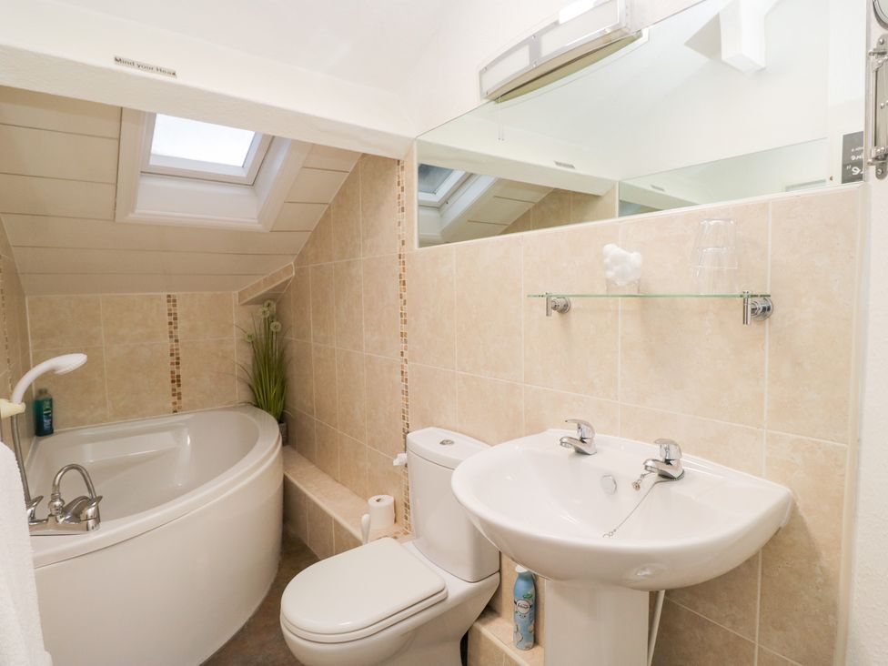 A bathroom with a bathtub, toilet, and sink at Norwood House in Ambleside