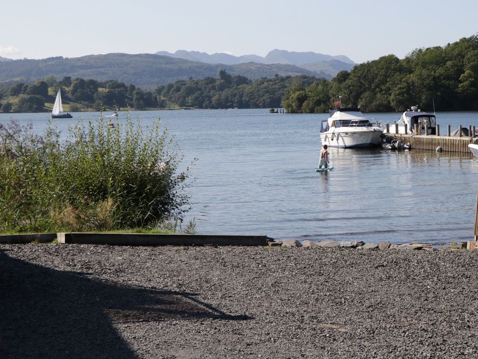 A lake with boats and a paddleboarder at Norwood House Ambleside