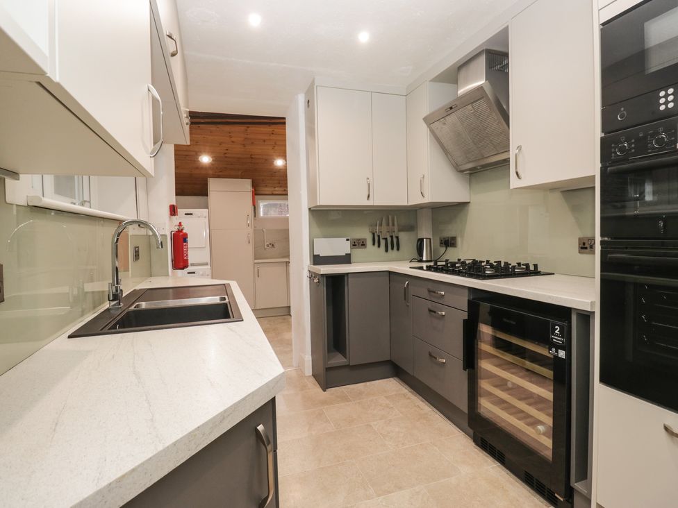 A kitchen with a sink, stove, and refrigerator at Norwood House in Ambleside
